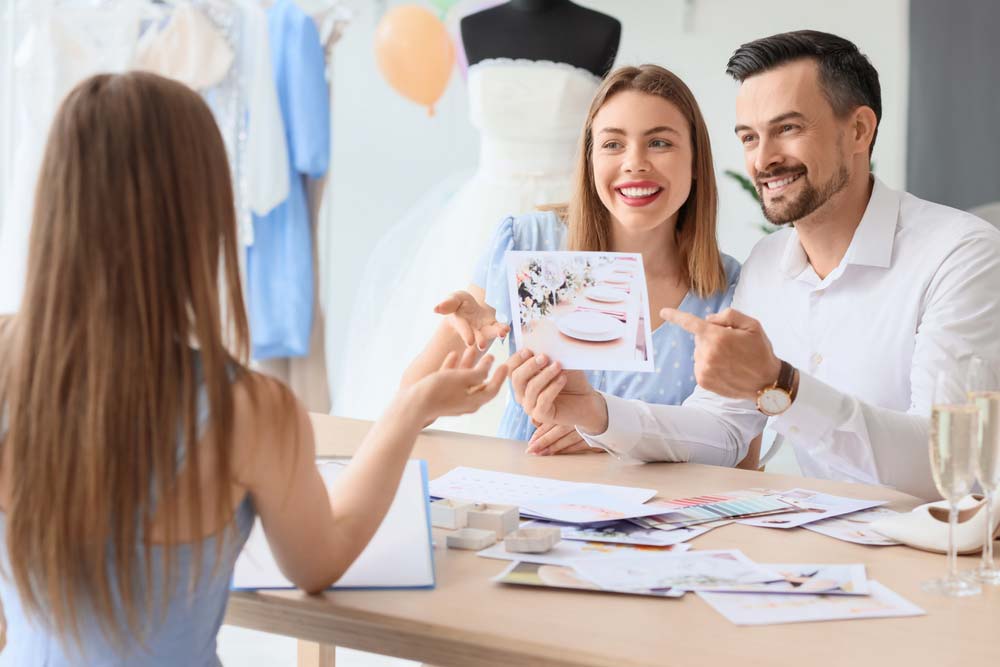 A smiling couple meeting with a wedding planner