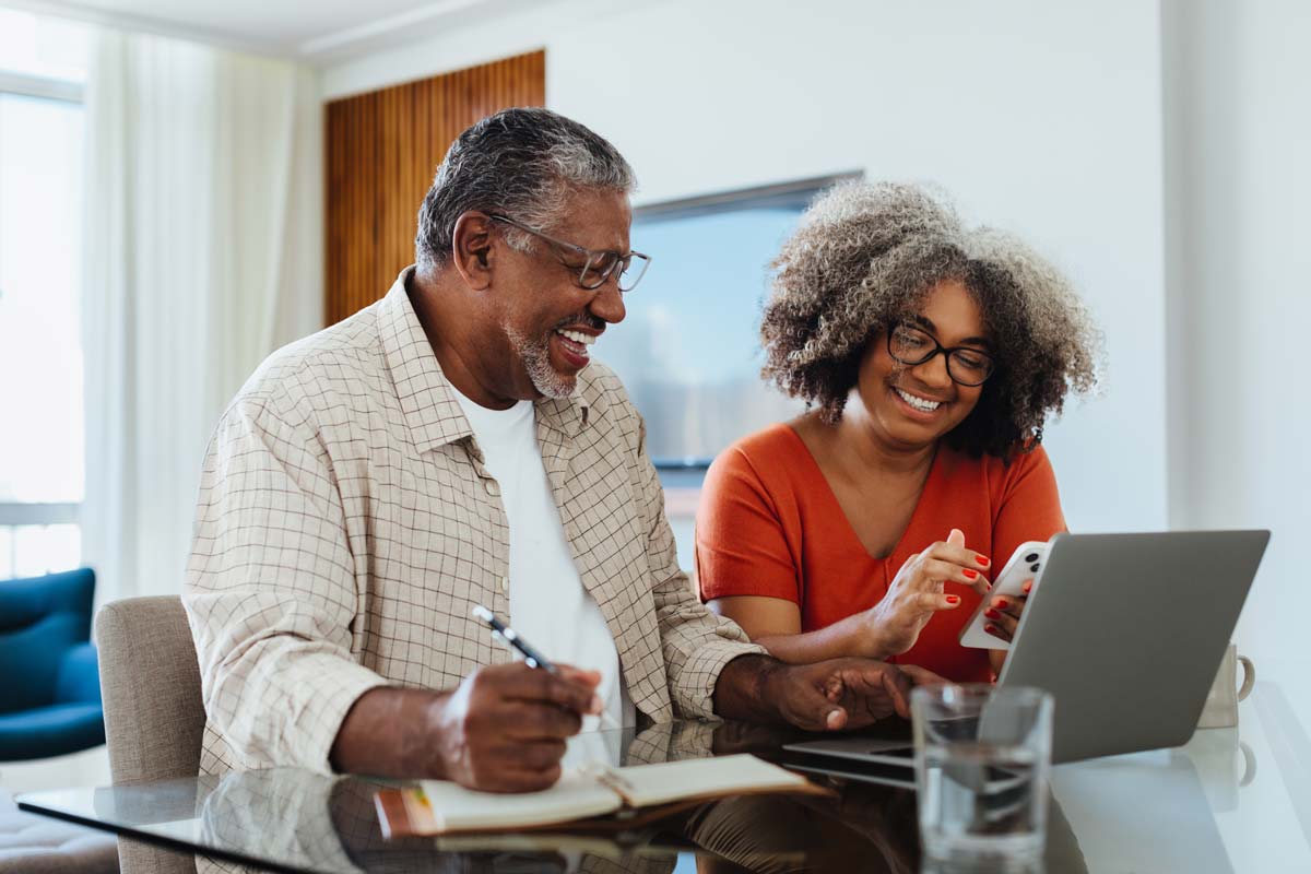 An elderly couple conducting retirement planning on their laptop.