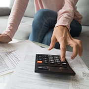 A woman calculating her finances on a coffee table.