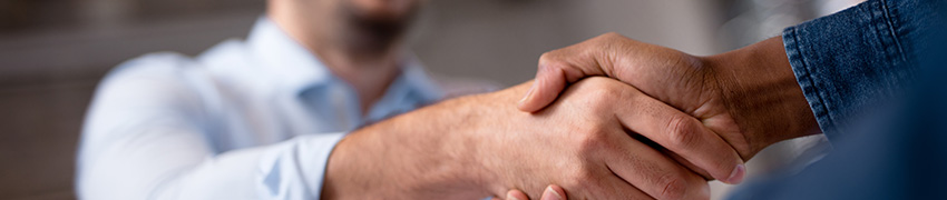 A smiling man shaking hands with a banker