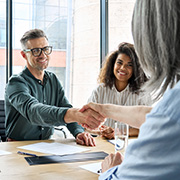 A group of people shaking hands at a financial meeting.